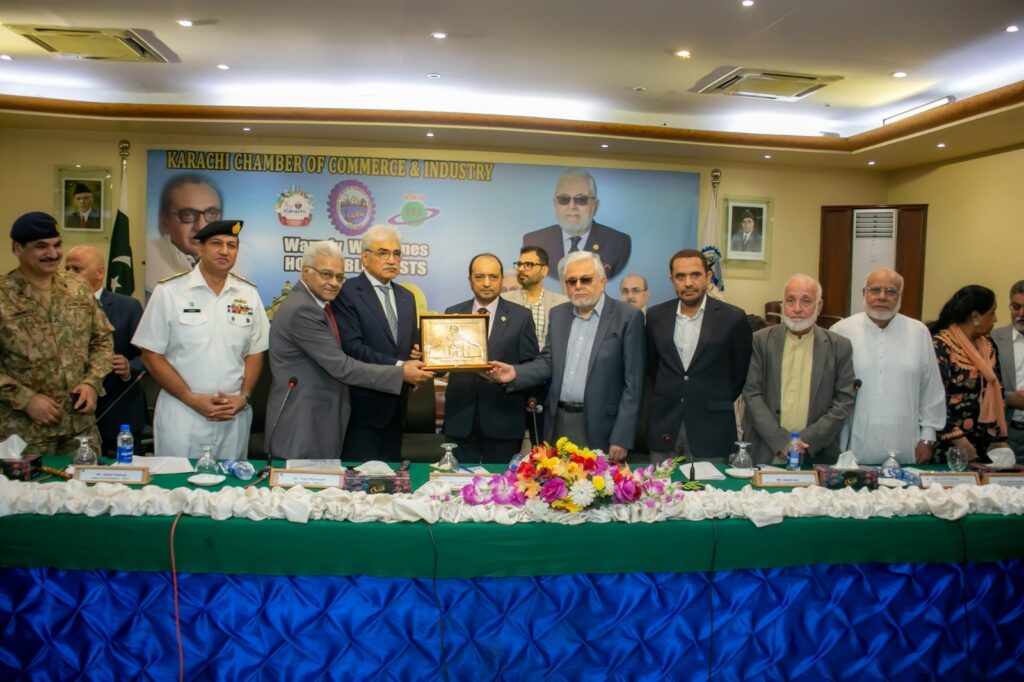 Karachi Port Trust Chairman Shahid Ahmed receives a crest from Zubair Motiwala and Talat Mahmood at KCCI.