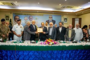 Karachi Port Trust Chairman Shahid Ahmed receives a crest from Zubair Motiwala and Talat Mahmood at KCCI.